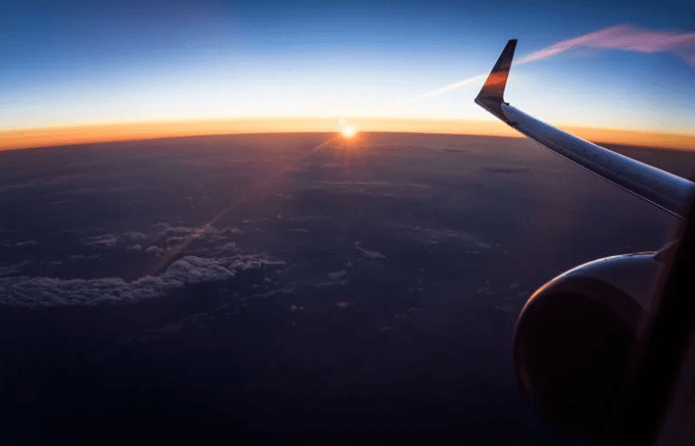 Airplane wing and clouds view from passenger window seat